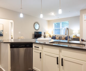 kitchen with natural light, stainless steel dishwasher, TV, dark countertops, pendant lighting, white cabinets, and light flooring, Ellington Midtown