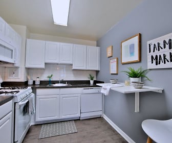 kitchen featuring refrigerator, gas range oven, dishwasher, microwave, dark countertops, white cabinets, and light hardwood floors, Willow Run at Mark Center