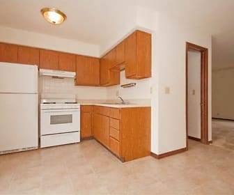 kitchen featuring extractor fan, refrigerator, range oven, light tile floors, light countertops, and brown cabinetry, Candlelight Park