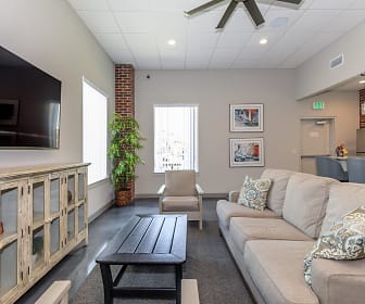 carpeted living room featuring a ceiling fan, natural light, refrigerator, and TV, Crosswinds Apartments
