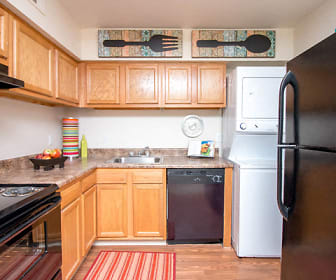 kitchen with refrigerator, electric range oven, extractor fan, washer / dryer, dishwasher, granite-like countertops, light flooring, and light brown cabinets, Monarch Crossing Apartment Homes