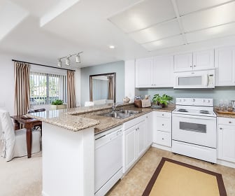 kitchen with natural light, refrigerator, electric range oven, dishwasher, microwave, white cabinets, light tile floors, and light stone countertops, San Remo Villa Apartment Homes