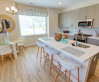 kitchen with natural light, stainless steel microwave, light countertops, white cabinetry, and light parquet floors, Woodland Green in Bloomfield NEW CONSTRUCTION