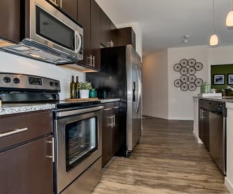 kitchen featuring stainless steel appliances, electric range oven, granite-like countertops, pendant lighting, dark floors, and dark brown cabinets, Westlink at Oak Station