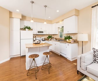 kitchen featuring natural light, a kitchen breakfast bar, refrigerator, dishwasher, microwave, light hardwood floors, pendant lighting, white cabinets, and light countertops, Woodbury Place