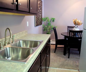 kitchen with carpet, refrigerator, dark flooring, light countertops, and dark brown cabinets, Rosedale Estates