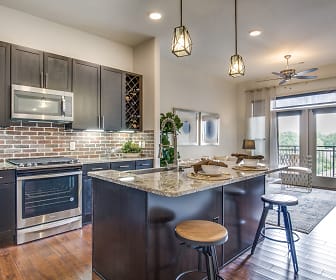 kitchen featuring a ceiling fan, natural light, stainless steel microwave, range oven, dark brown cabinetry, pendant lighting, light stone countertops, and light parquet floors, Sinclair