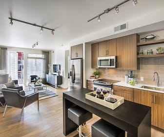 kitchen with stainless steel appliances, light hardwood flooring, brown cabinets, and light countertops, 8000 Uptown
