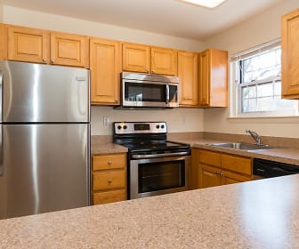 kitchen featuring natural light, stainless steel appliances, electric range oven, light granite-like countertops, and brown cabinetry, Valley Apartments