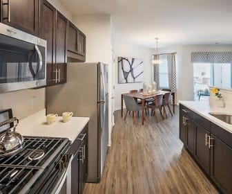 kitchen featuring natural light, stainless steel appliances, pendant lighting, dark brown cabinetry, light countertops, and light parquet floors, Summit Court