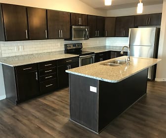 kitchen featuring a center island, electric range oven, stainless steel appliances, dark brown cabinetry, dark parquet floors, light granite-like countertops, and pendant lighting, Grayhawk Apartments