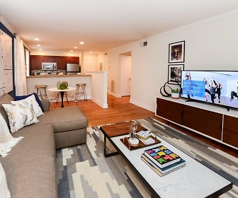 hardwood floored living room featuring a breakfast bar area, refrigerator, and TV, The Villas at Bryn Mawr Apartment Homes