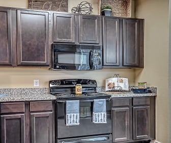 kitchen with electric range oven, microwave, stone countertops, and dark brown cabinets, Chateau Mirage