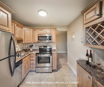 kitchen featuring stainless steel appliances, electric range oven, light tile floors, brown cabinets, and dark stone countertops, Rivercrest Apartments