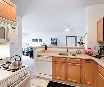 kitchen featuring dishwasher, microwave, light countertops, light tile flooring, and brown cabinets, Settler's Landing