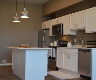 kitchen featuring a center island, stainless steel appliances, range oven, dark hardwood floors, pendant lighting, white cabinets, and light countertops, 29 West Apartments