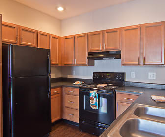 kitchen with refrigerator, electric range oven, extractor fan, dark countertops, brown cabinets, and dark hardwood flooring, The Overlook At Golden Hills