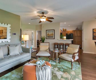 living room featuring a ceiling fan, hardwood flooring, and refrigerator, Golf Brook Apartments at Sabal Point