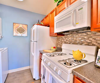 kitchen with washer / dryer, refrigerator, gas range oven, microwave, granite-like countertops, light brown cabinets, and light parquet floors, Briarwood Place Apartment Homes