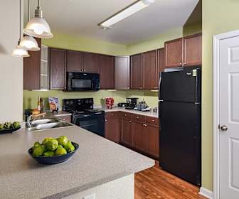 kitchen featuring refrigerator, electric range oven, microwave, light countertops, pendant lighting, light parquet floors, and dark brown cabinets, The Park at Walnut Ridge
