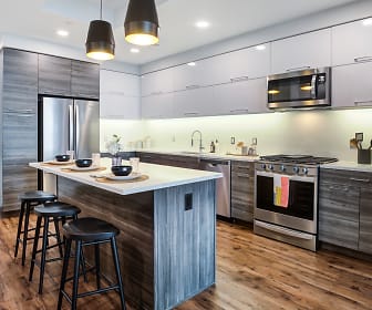 kitchen with a center island, stainless steel appliances, gas range oven, dark parquet floors, pendant lighting, dark brown cabinetry, and light countertops, Gables Vista