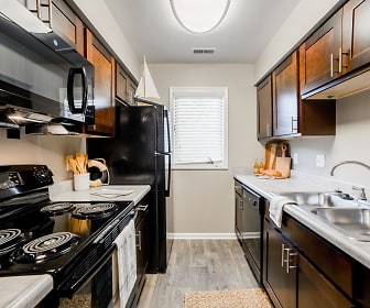 kitchen with natural light, refrigerator, electric range oven, dishwasher, microwave, dark brown cabinetry, light countertops, and light parquet floors, Northlake Village Apartments