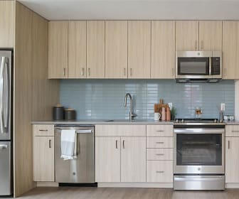 kitchen featuring stainless steel appliances, range oven, light brown cabinetry, light countertops, and light parquet floors, The Clara