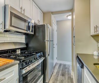 kitchen with refrigerator, gas range oven, dishwasher, stainless steel microwave, white cabinetry, and light hardwood floors, The Maynard at 5115 N Sheridan