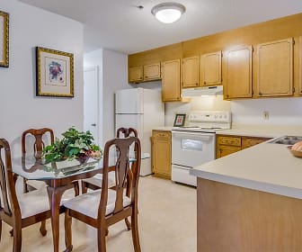 kitchen with refrigerator, electric range oven, exhaust hood, light countertops, light tile flooring, and brown cabinets, Woodbrook Apartments