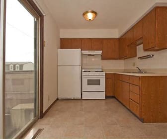 kitchen with natural light, refrigerator, range oven, exhaust hood, light countertops, light tile floors, and brown cabinets, Candlelight Park