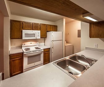 kitchen with washer / dryer, refrigerator, electric range oven, microwave, light countertops, and dark brown cabinets, Bexley Village