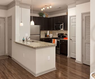 kitchen with a kitchen island, stainless steel appliances, range oven, dark brown cabinetry, dark parquet floors, pendant lighting, and light stone countertops, Terraces at Suwanee Gateway