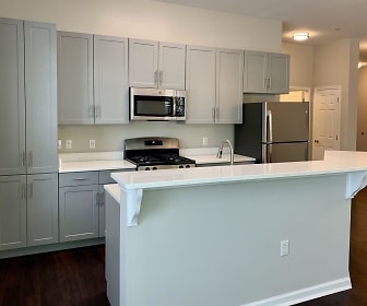 kitchen featuring a kitchen island, stainless steel appliances, range oven, white cabinets, light countertops, and dark hardwood flooring, The Kentshire- Senior Living