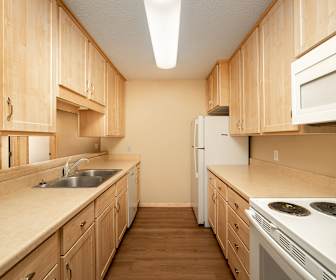 kitchen with refrigerator, dishwasher, microwave, light brown cabinetry, light countertops, and dark hardwood flooring, Park Villa Apartments