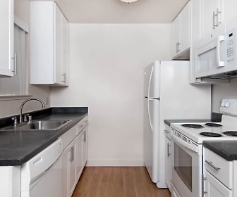 kitchen featuring refrigerator, electric range oven, dishwasher, microwave, dark countertops, white cabinetry, and light hardwood flooring, Skylark
