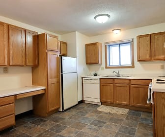 kitchen with natural light, refrigerator, dishwasher, electric range oven, fume extractor, dark tile floors, brown cabinets, and light countertops, Parkwest Gardens