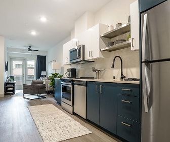 kitchen featuring stainless steel refrigerator, range oven, dishwasher, microwave, light hardwood floors, light countertops, and dark brown cabinets, The Press Apartments