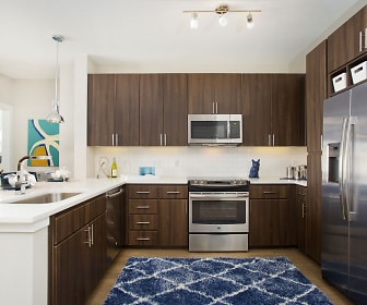 kitchen featuring natural light, stainless steel appliances, range oven, light flooring, dark brown cabinetry, light countertops, and pendant lighting, Broadstone On 9th