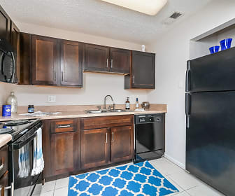 kitchen with refrigerator, electric range oven, dishwasher, microwave, dark brown cabinetry, light countertops, and light tile floors, The Park at Lake Magdalene
