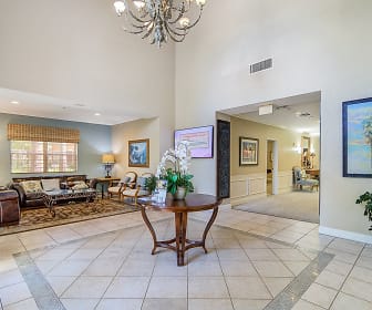 community lobby featuring a notable chandelier, tile floors, and natural light, Palm Island Senior Living +55