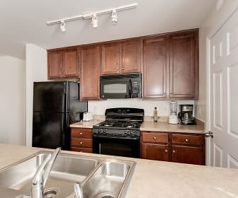 kitchen featuring gas range oven, refrigerator, microwave, light countertops, and dark brown cabinets, Park at Arlington Ridge