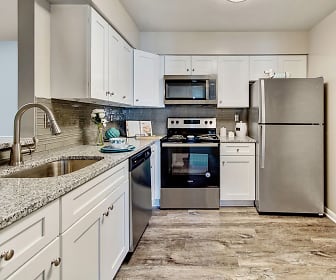 kitchen featuring electric range oven, refrigerator, dishwasher, stainless steel microwave, light tile floors, white cabinets, and light granite-like countertops, Northampton Apartment Homes