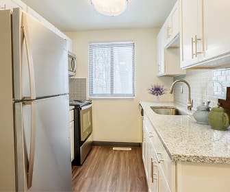 kitchen with natural light, stainless steel refrigerator, range oven, microwave, dark hardwood floors, white cabinetry, and granite-like countertops, High Acres