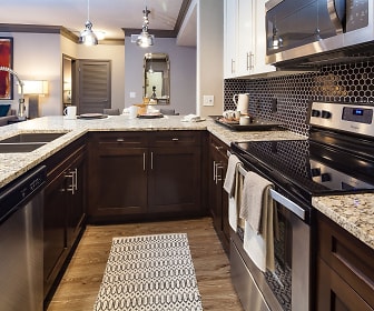 kitchen featuring stainless steel appliances, electric range oven, pendant lighting, light stone countertops, dark brown cabinetry, and light hardwood floors, Cortland Lake Lotus