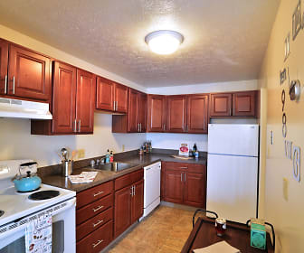 kitchen with extractor fan, refrigerator, electric range oven, dishwasher, dark brown cabinetry, dark countertops, and light tile floors, Midtown Towers