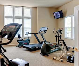 exercise room with carpet, a healthy amount of sunlight, and TV, The Reserve at Prairie Point & Prairie Point Apartments