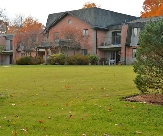 back of house featuring an expansive lawn, Pinewood Creek Apartments