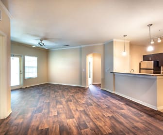 kitchen featuring natural light, a ceiling fan, refrigerator, kitchen island sink, light countertops, dark hardwood flooring, dark brown cabinetry, and pendant lighting, Mirador & Stovall Apartments At River City