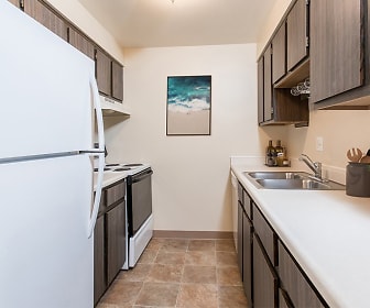 kitchen featuring refrigerator, electric range oven, exhaust hood, dark brown cabinetry, light countertops, and light tile floors, Crossroads Apartments