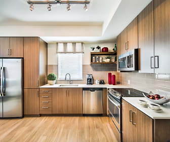 kitchen with natural light, electric range oven, stainless steel appliances, light countertops, dark brown cabinets, and light parquet floors, 8000 Uptown